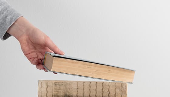 左手拿起桌上的一本书高清图片素材(JPG)