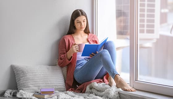 拿着咖啡坐在窗台看书的女子高清图片素材(JPG)