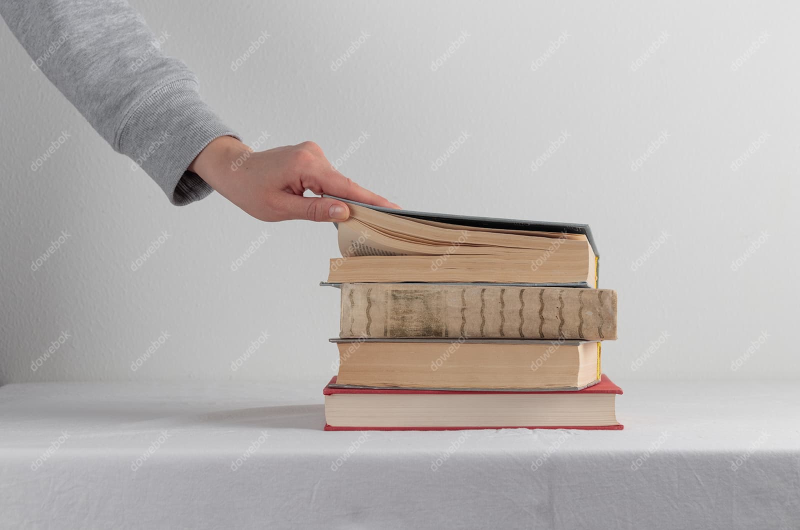 翻开堆叠书本的左手高清图片素材(JPG)