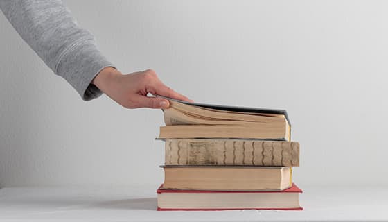 翻开堆叠书本的左手高清图片素材(JPG)