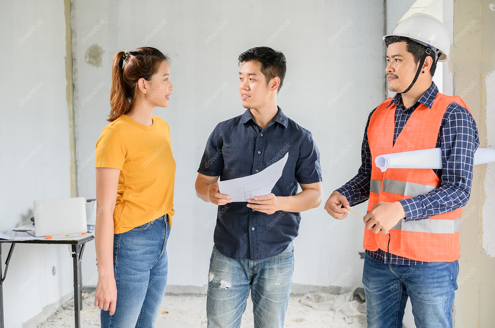拿着图纸一起讨论工作的工人高清图片素材(JPG)