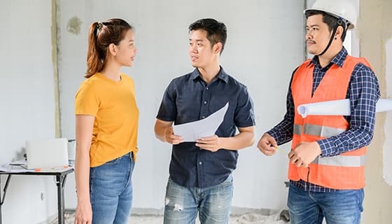 拿着图纸一起讨论工作的工人高清图片素材(JPG)