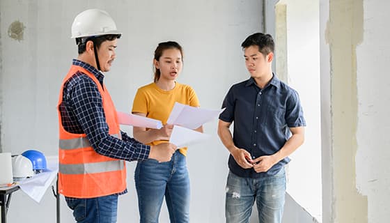 拿着图纸一起讨论工作的工人高清图片素材(JPG)