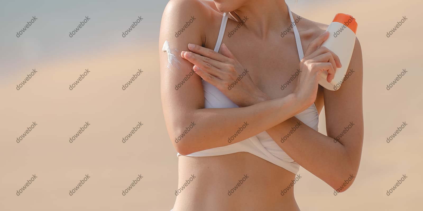 站在沙滩上涂防晒霜的女子图片素材(JPG)