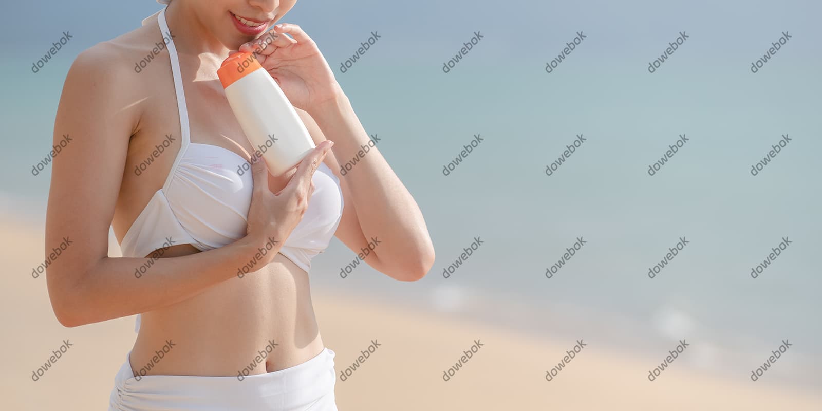 站在沙滩上涂防晒霜的女子图片素材(JPG)