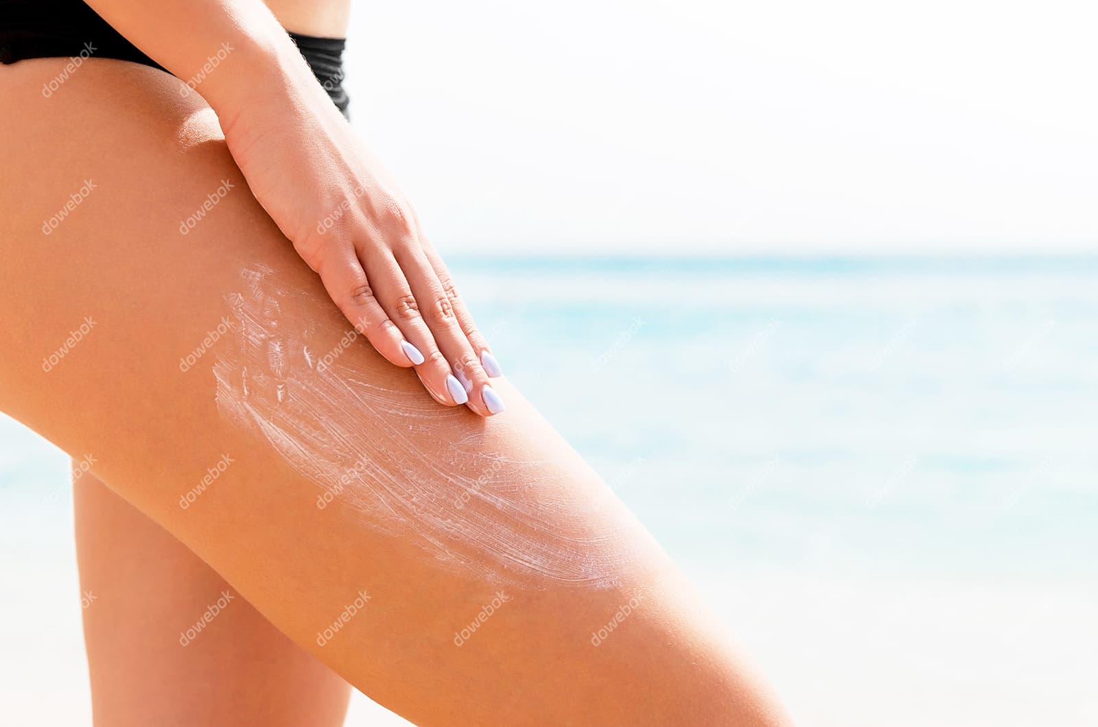往大腿上涂防晒霜图片素材(JPG)