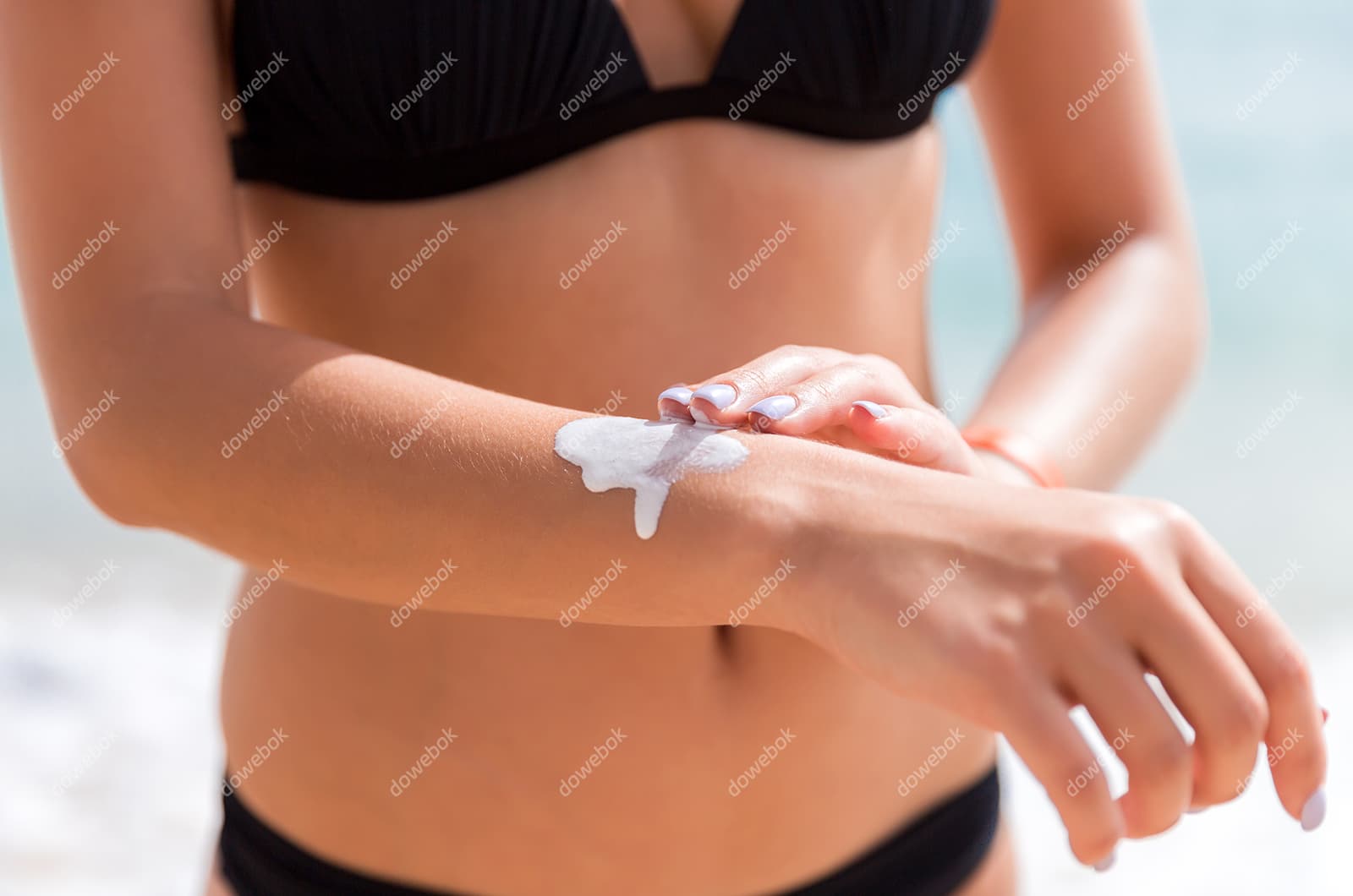 往手上涂防晒霜的女子图片素材(JPG)