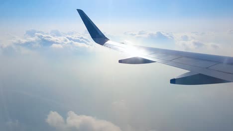 从窗户看飞机机翼掠过多云的天空