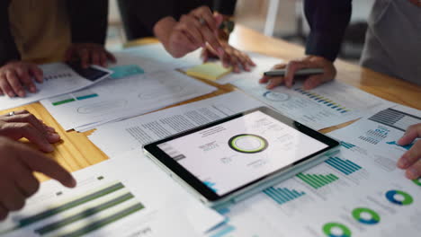 分析师们围绕着平板电脑上的数据进行讨论