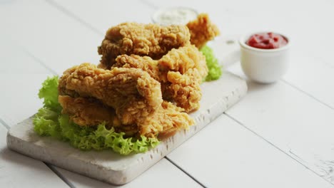 桌面上的炸鸡翅和番茄酱