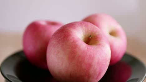 盘子里三个鲜红诱人的苹果