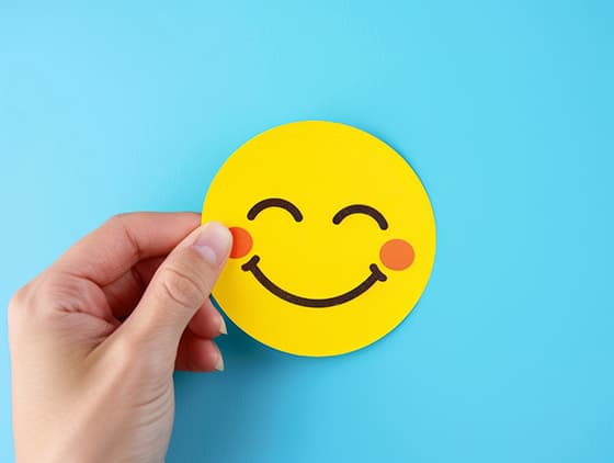 手拿一张微笑表情的黄色贴纸图片素材(JPG)