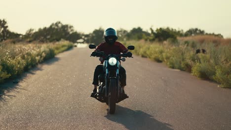 灿烂的阳光下骑摩托车的男子