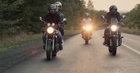 年轻人在郊外的公路上骑摩托车