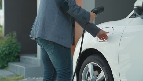 一名男子给他的新能源电动汽车插上电源