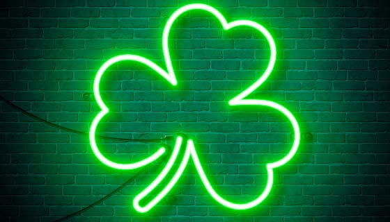 挂在砖墙上的绿色三叶草霓虹灯矢量素材(EPS)